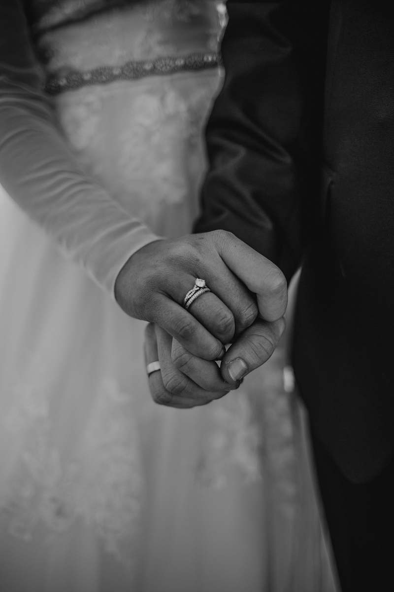 human grayscale photography of man and woman holding hand black-and-white