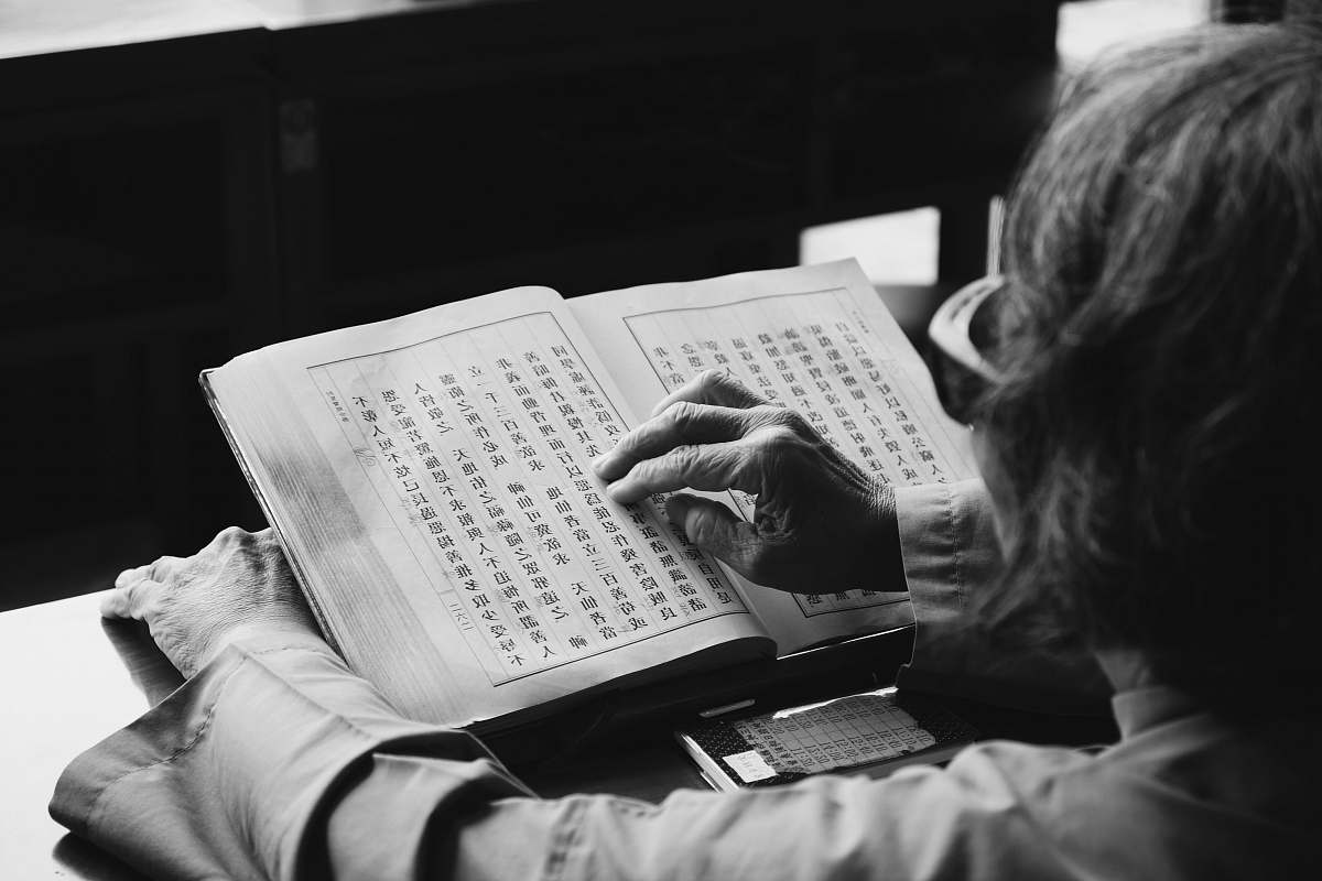 black-and-white grayscale photography of person reading book book