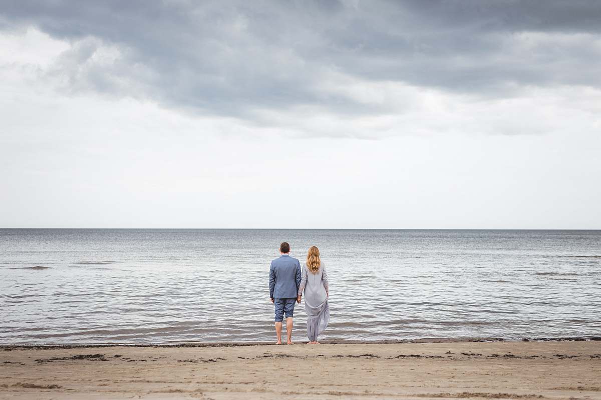 human man and woman standing on shore sea