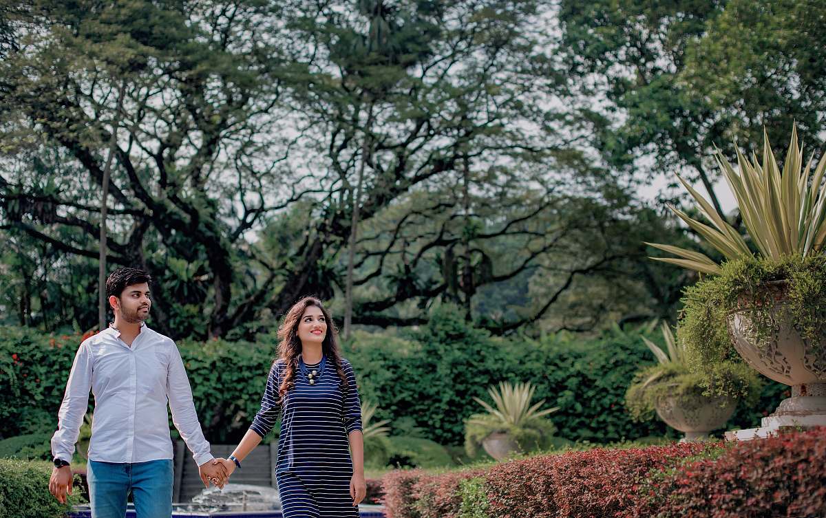 human man and woman walking hand in hand in park apparel