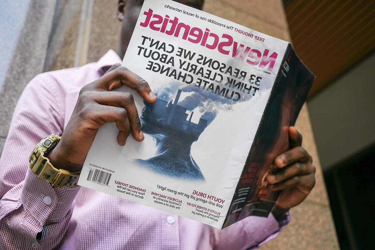 human man reading New Scientist book people
