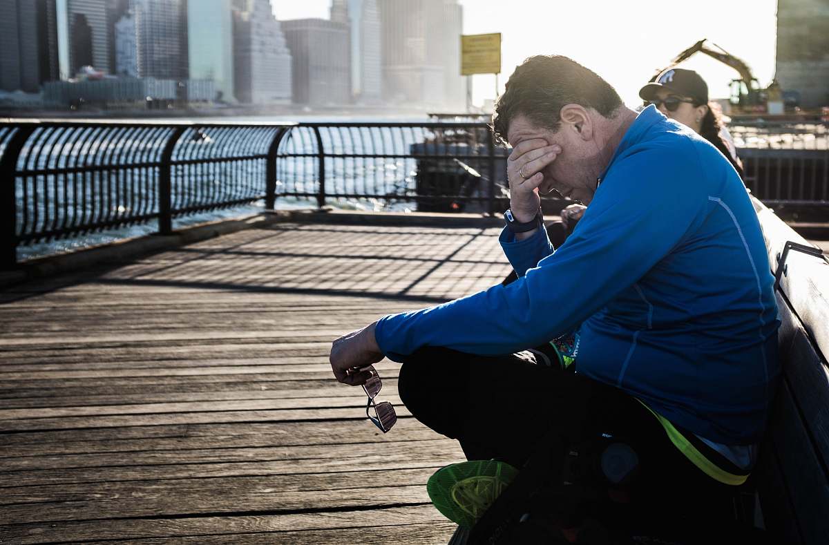 human man sitting on bench beside woman people
