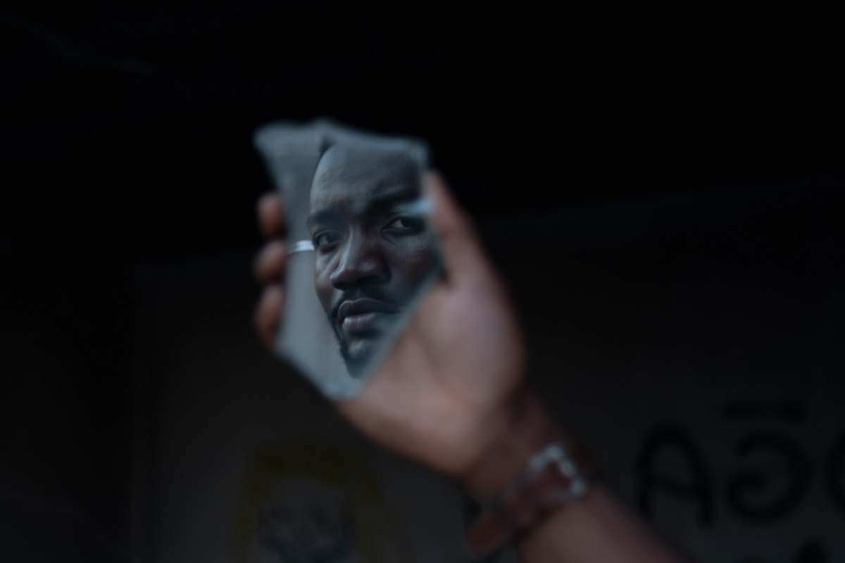 human man's face reflected on mirror finger