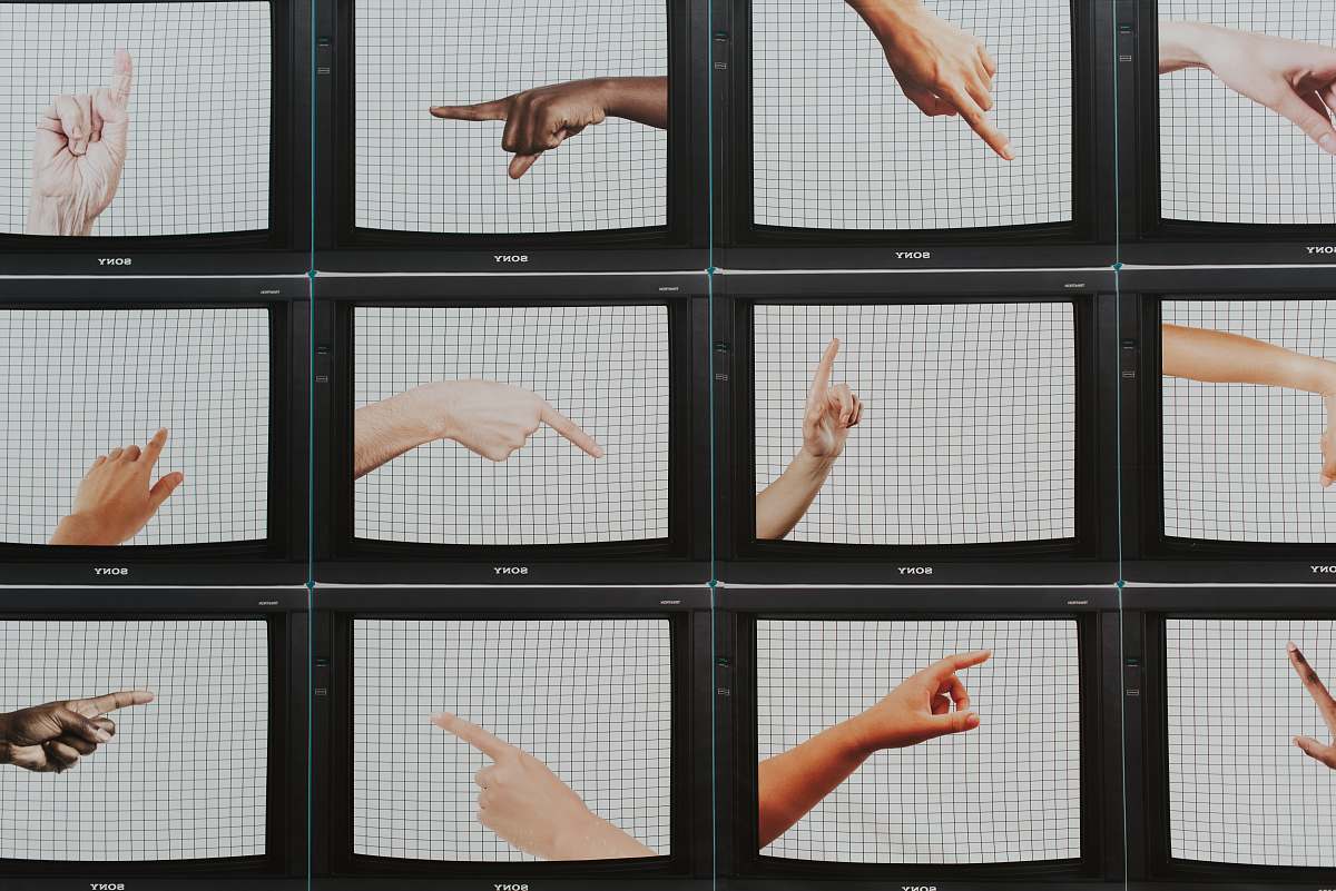 This captivating image features a wall adorned with a variety of hands, each representing different cultures and backgrounds. The human monitor standing in the foreground emphasizes the idea of connection and cooperation among diverse communities. Ideal for projects focusing on teamwork, inclusivity, or social advocacy, this visual can enhance marketing materials, educational content, or social media campaigns aimed at promoting unity and diversity.