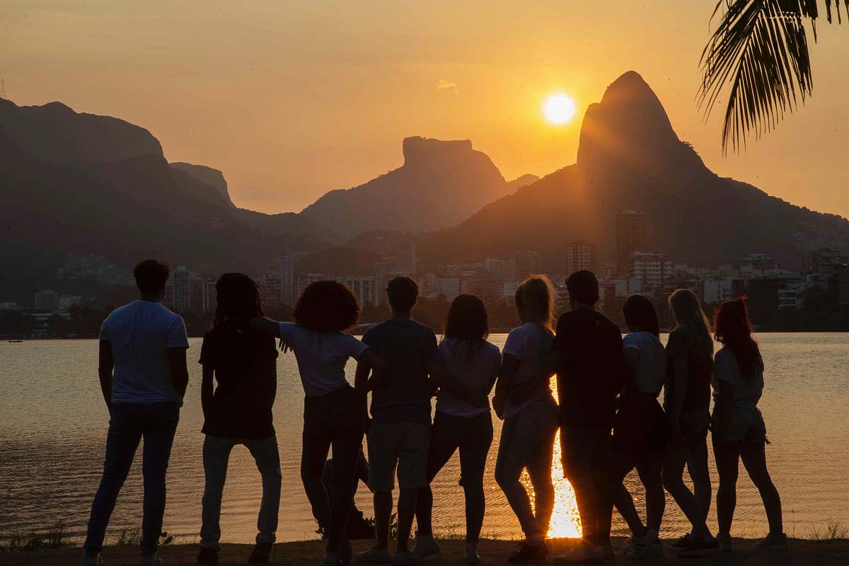 human people standing near body of water flare