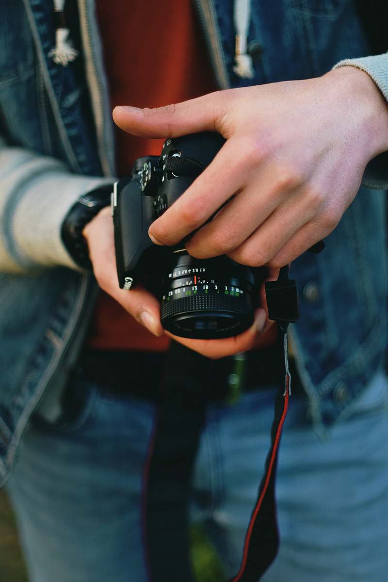 human person holding black Canon DSLR camera people