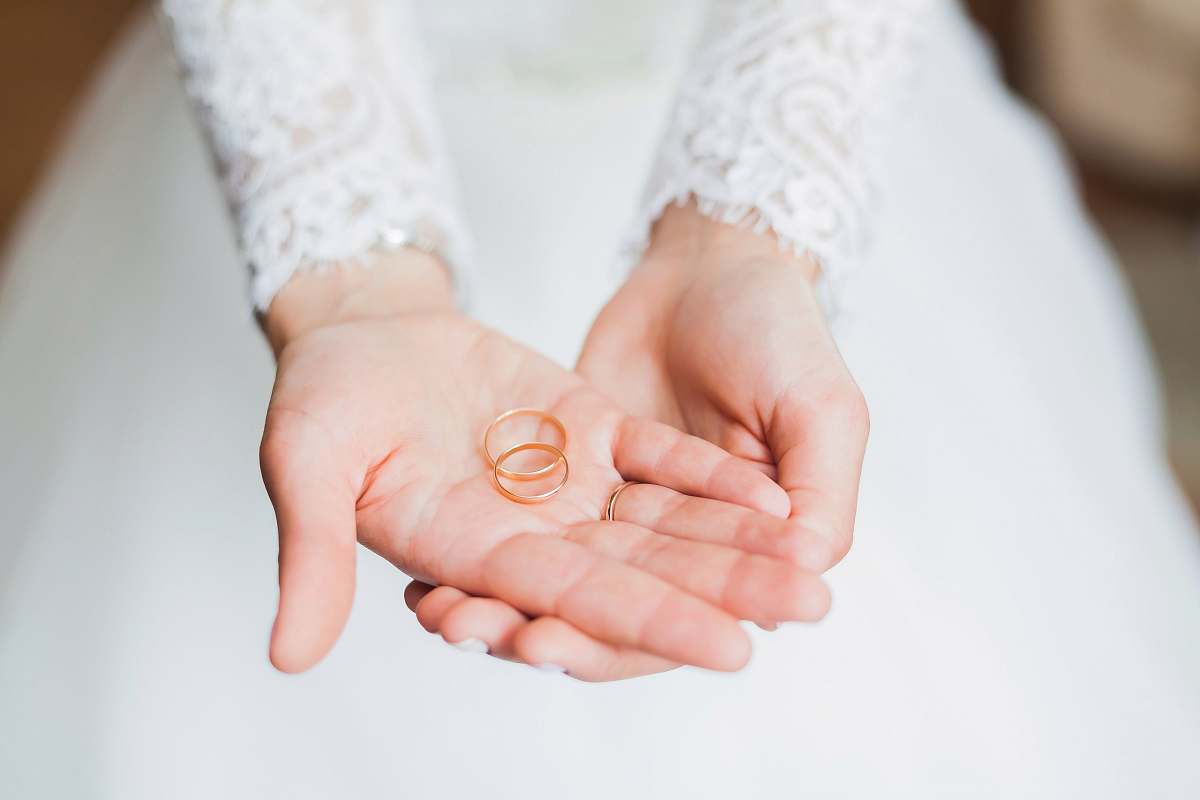 wedding person holding copper rings during daytime wedding ring