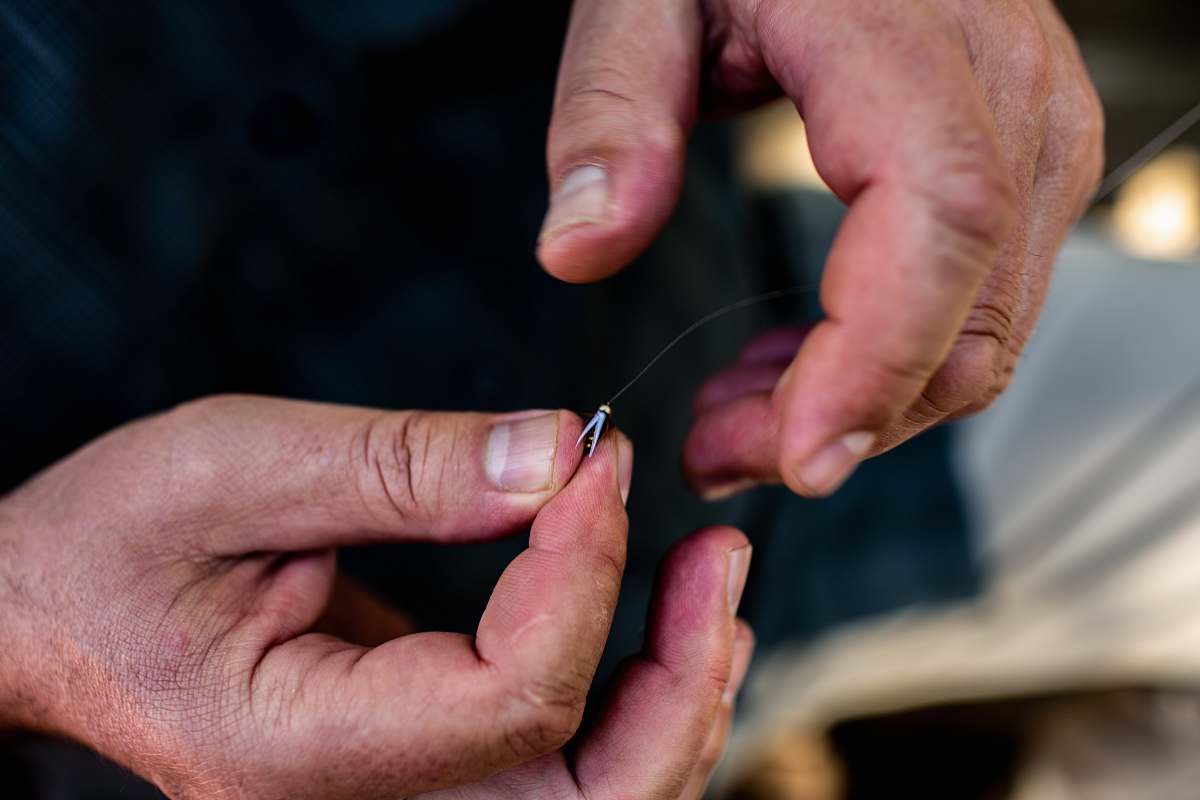 human person holding fishhook with line finger