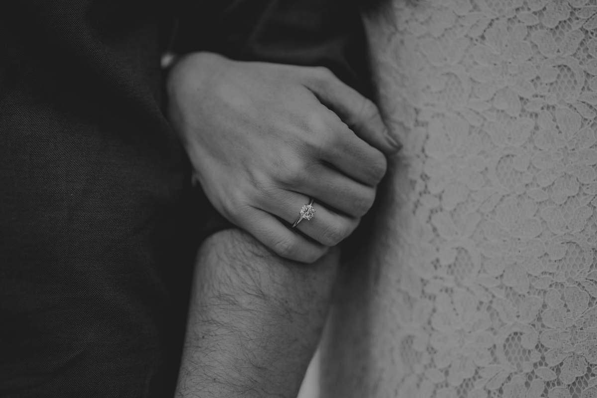 human person holding person's arm black-and-white