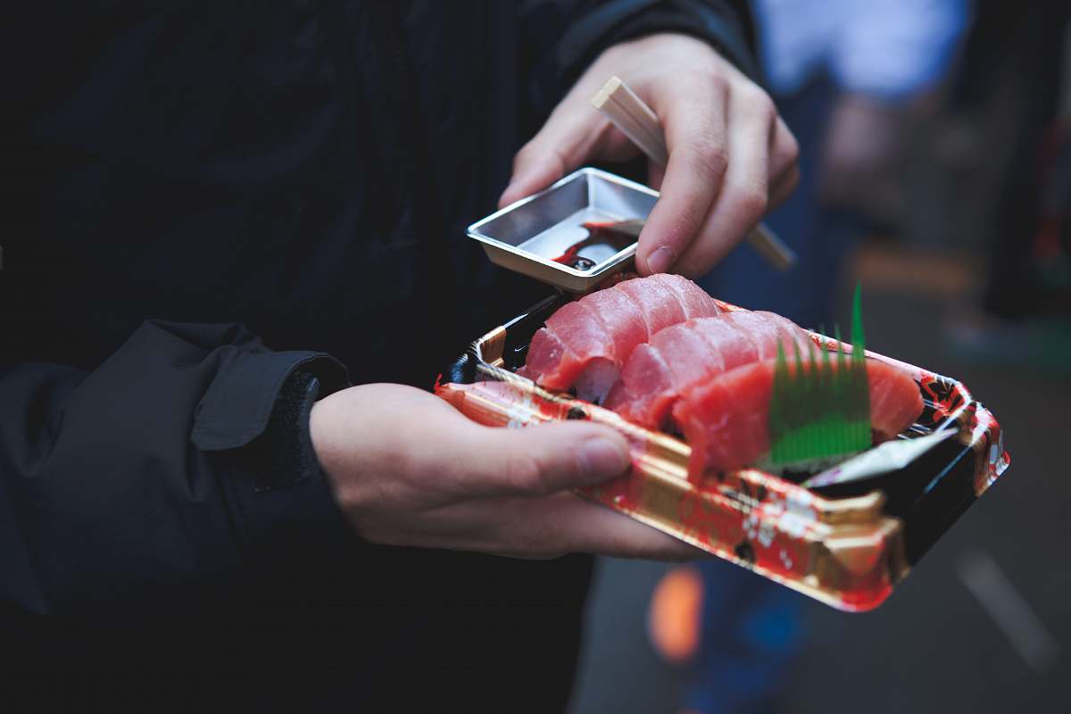 human person holding tuna sashimi food