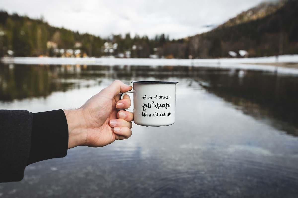 human person holding white ceramic mug cup