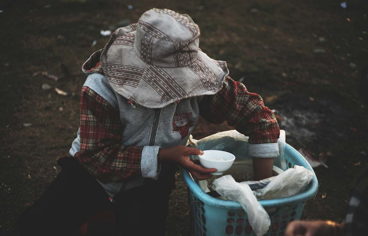 people person in hat holding bowl while hand inside basket human