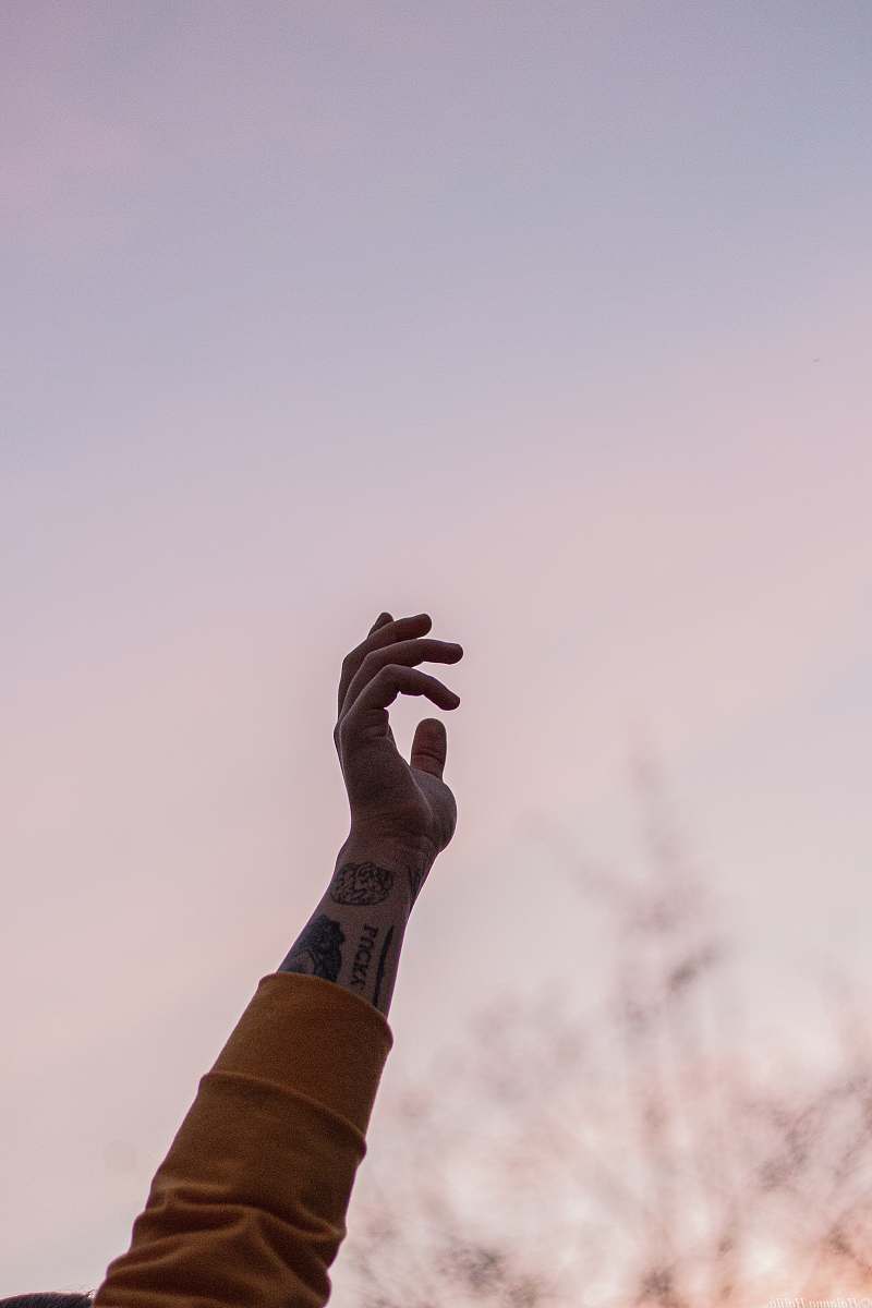 human person in orange long-sleeved shirt raising hand finger