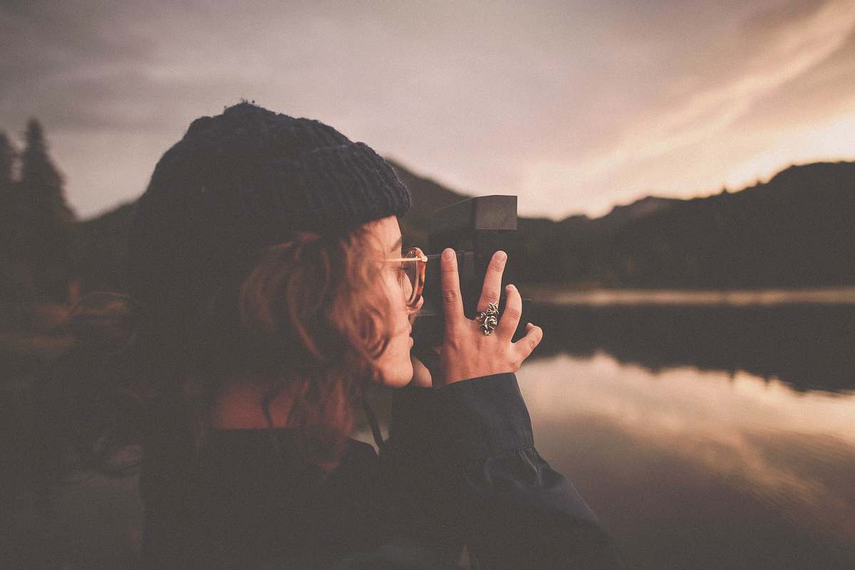 human photograph of woman taking a picture of body of water people