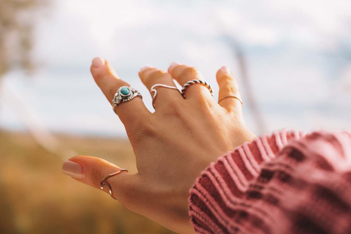 human selective focus photo of person's hand with five rings finger