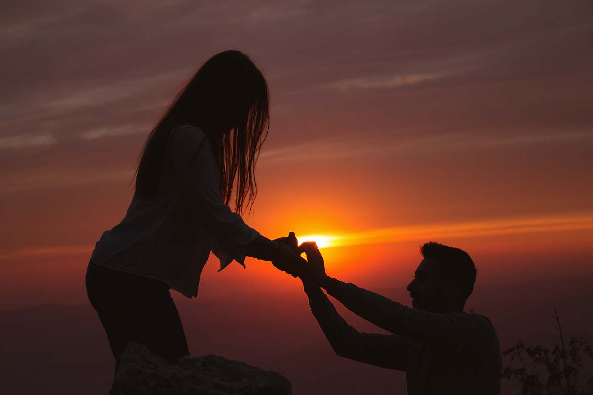 nature silhouette photography of man kneeling in front of woman outdoors