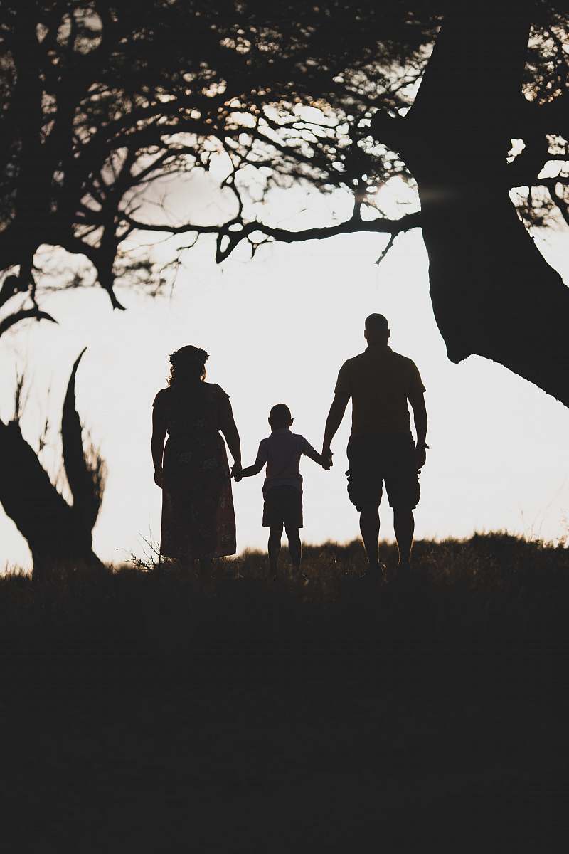 human three person standing in between of two tress during daytime grey-scale photography hand