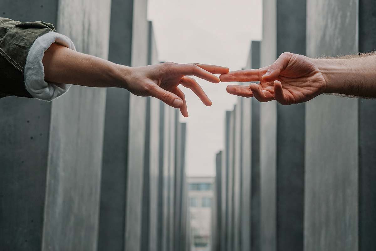 human two person touching each others finger tips hand