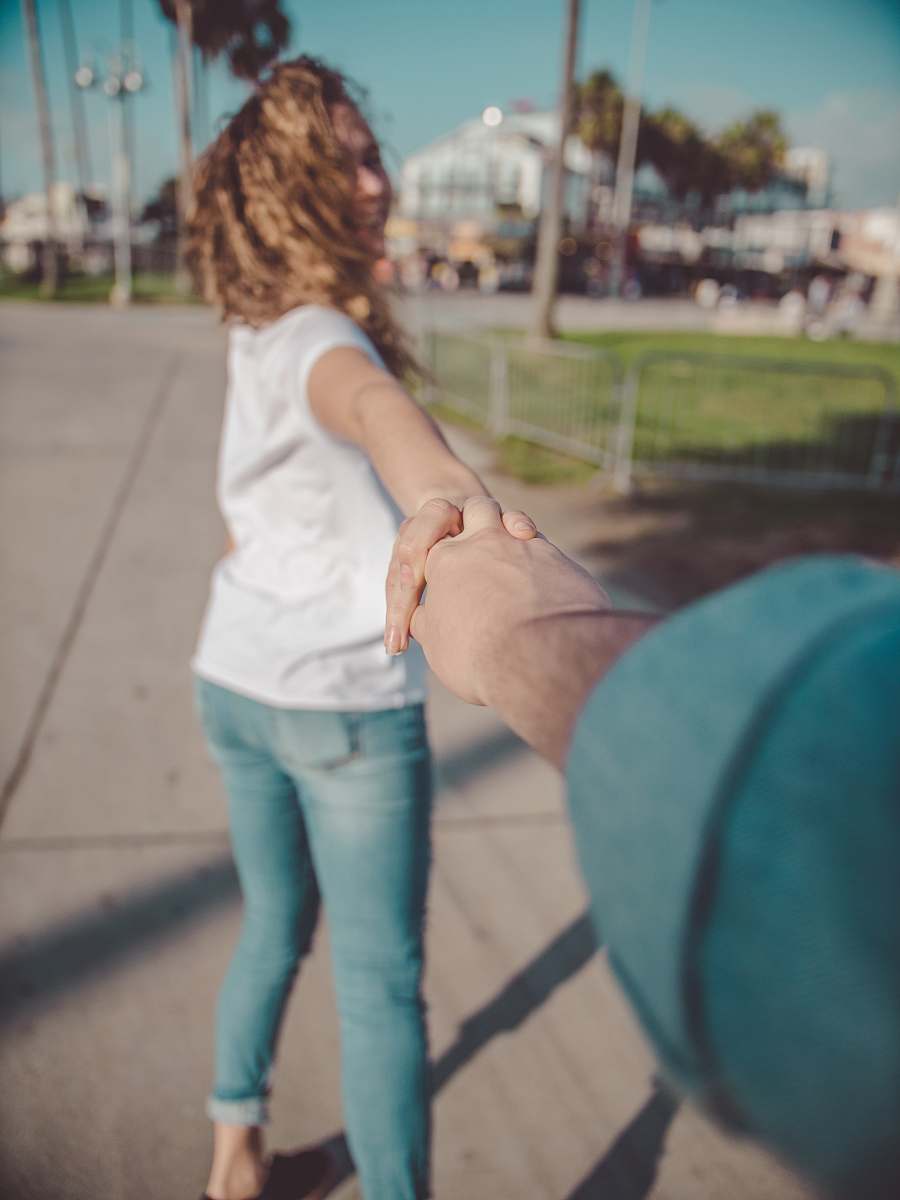 human woman holding hands with person during daytime holding hands