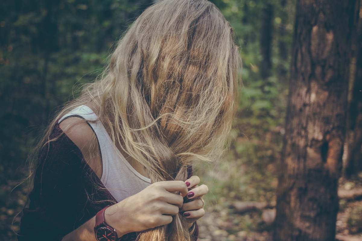 people woman holding her hair in forest woman