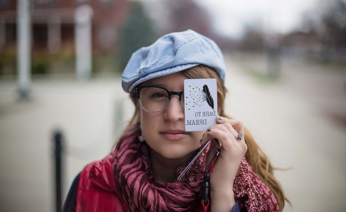 human woman holding white card dare