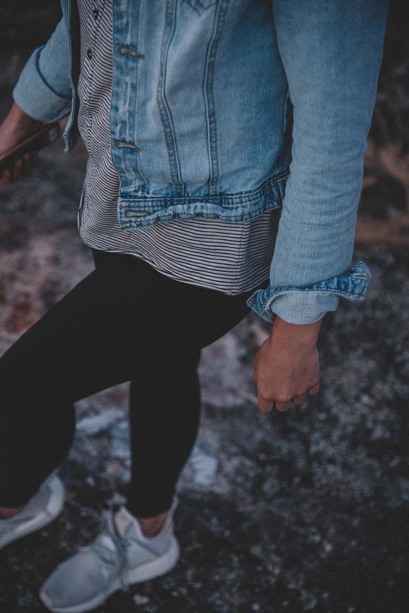 human woman in black leggings walking on gray concrete floor people