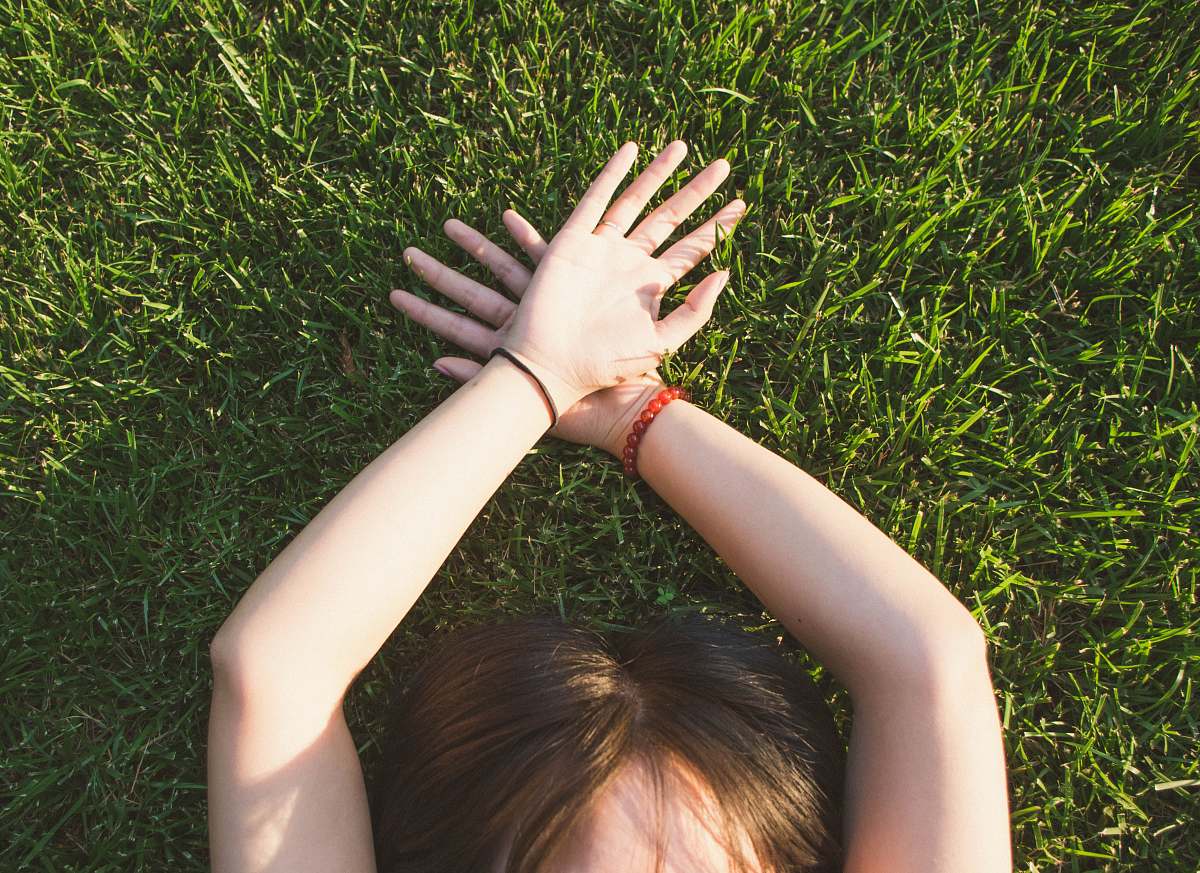 human woman lying on green grass grass