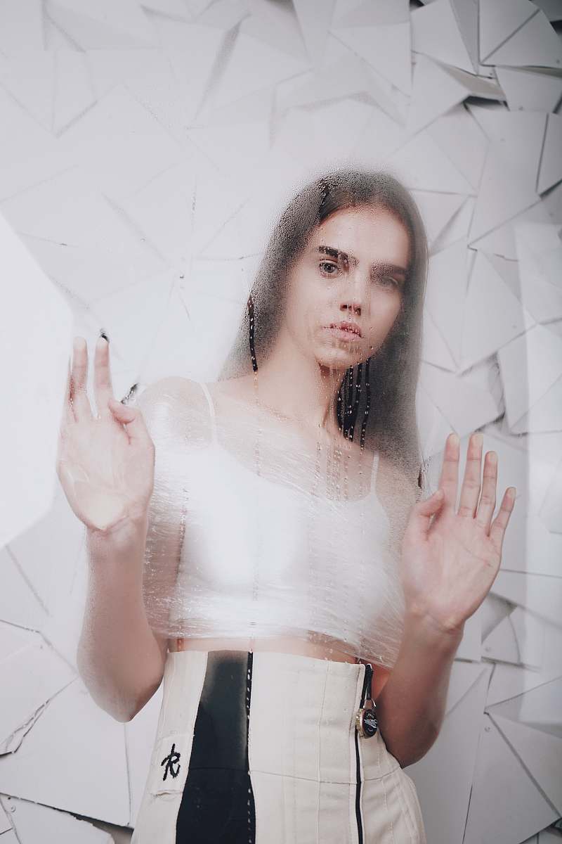 human woman standing in front of glass panel hand