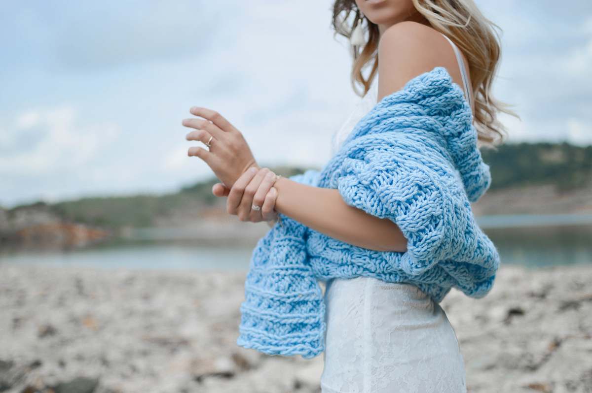 people woman wearing teal crochet top and white skirt woman