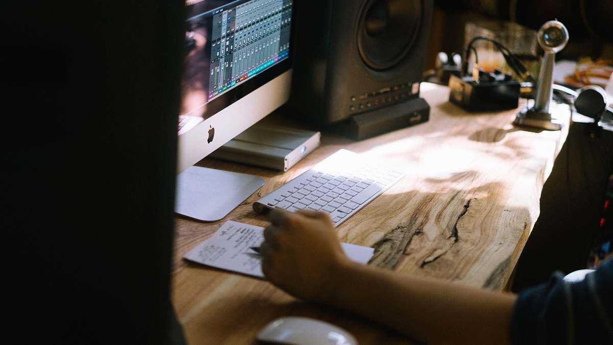 desk person using silver iMac, Apple Magic Keyboard, and Magic Mouse set office