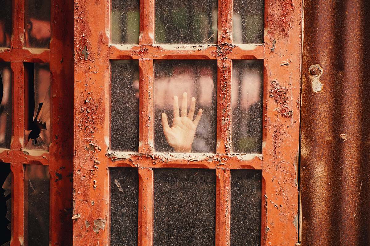rust person hand on glass panel door with red wooden frame door