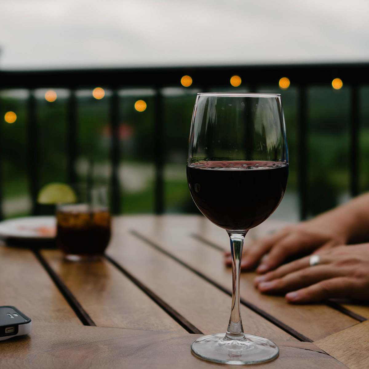 glass person hand on top of a table drink