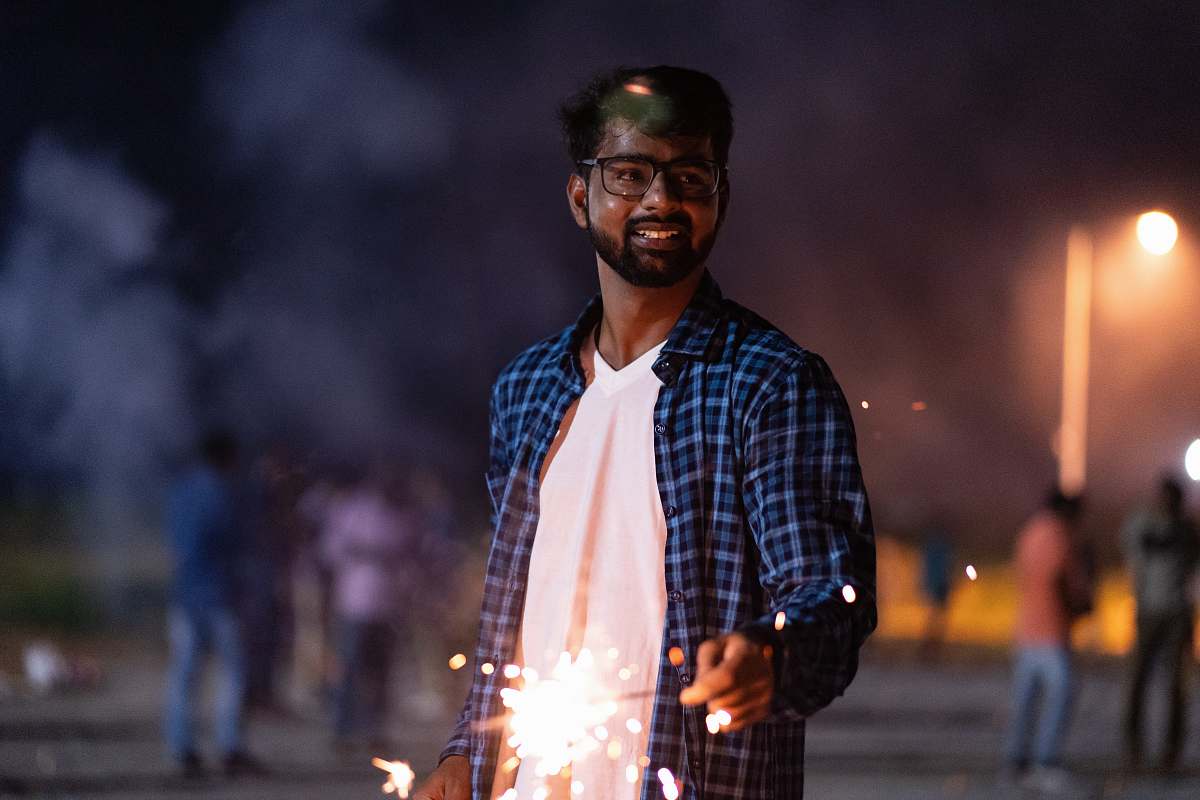 person man holding lightened sparkler outdoor at night human