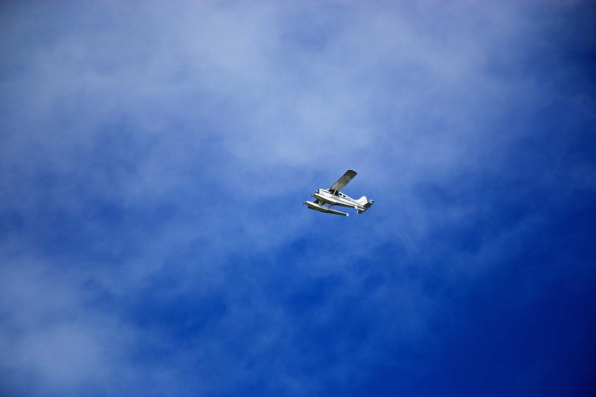 aircraft white flying biplane during white and blue sky seaplane