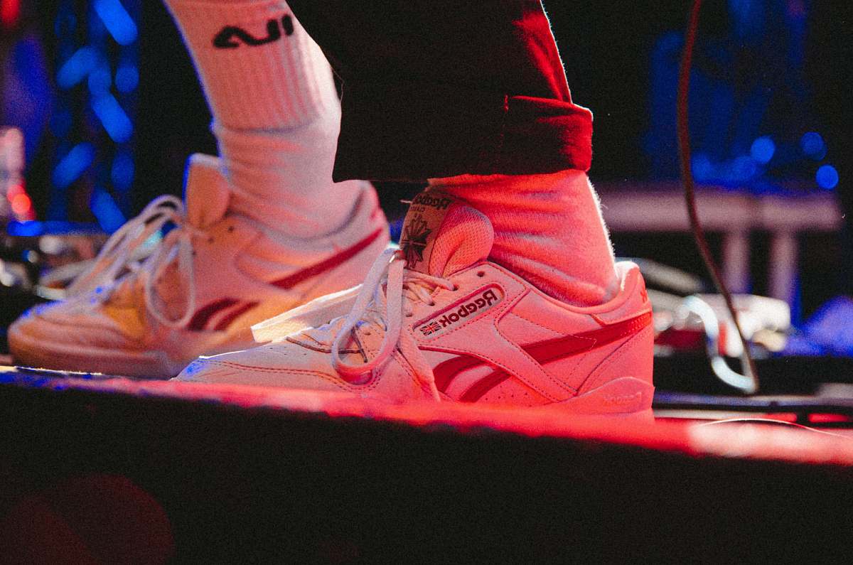 clothing person wearing pair of white Reebok high-top shoes footwear