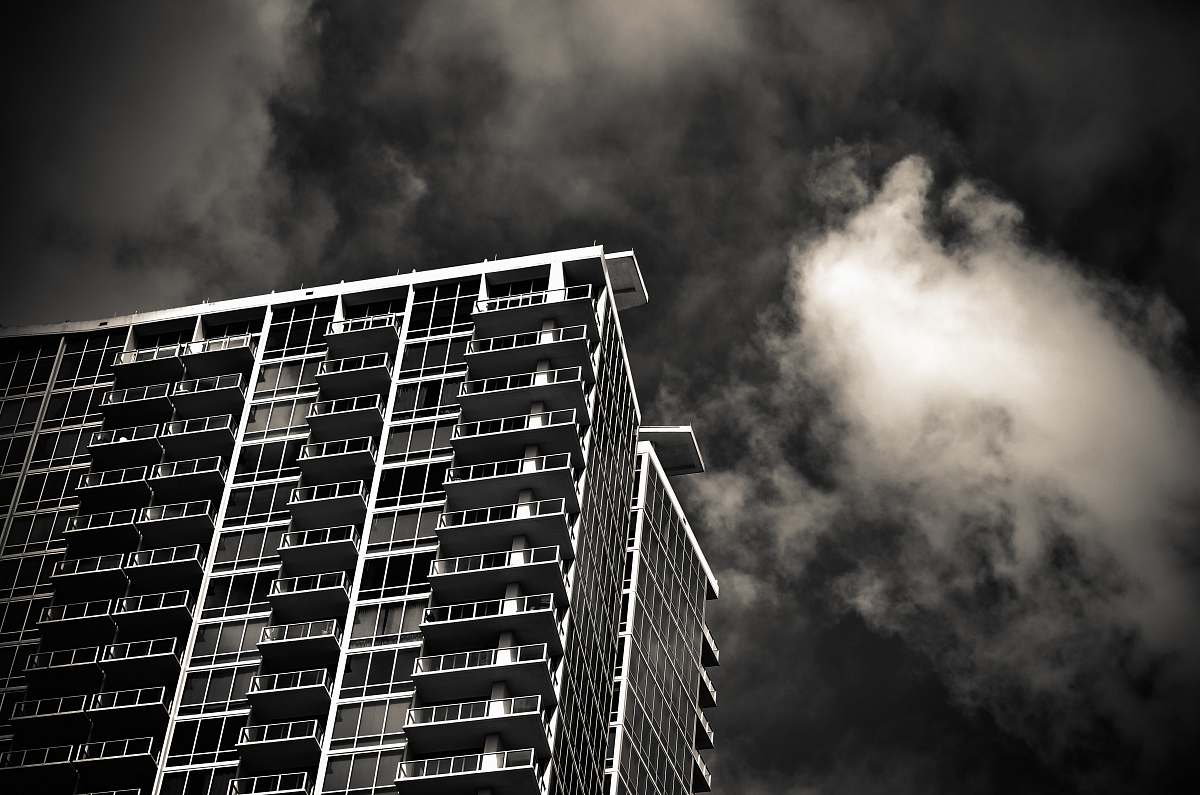 building grayscale photography of building under cloudy sky urban
