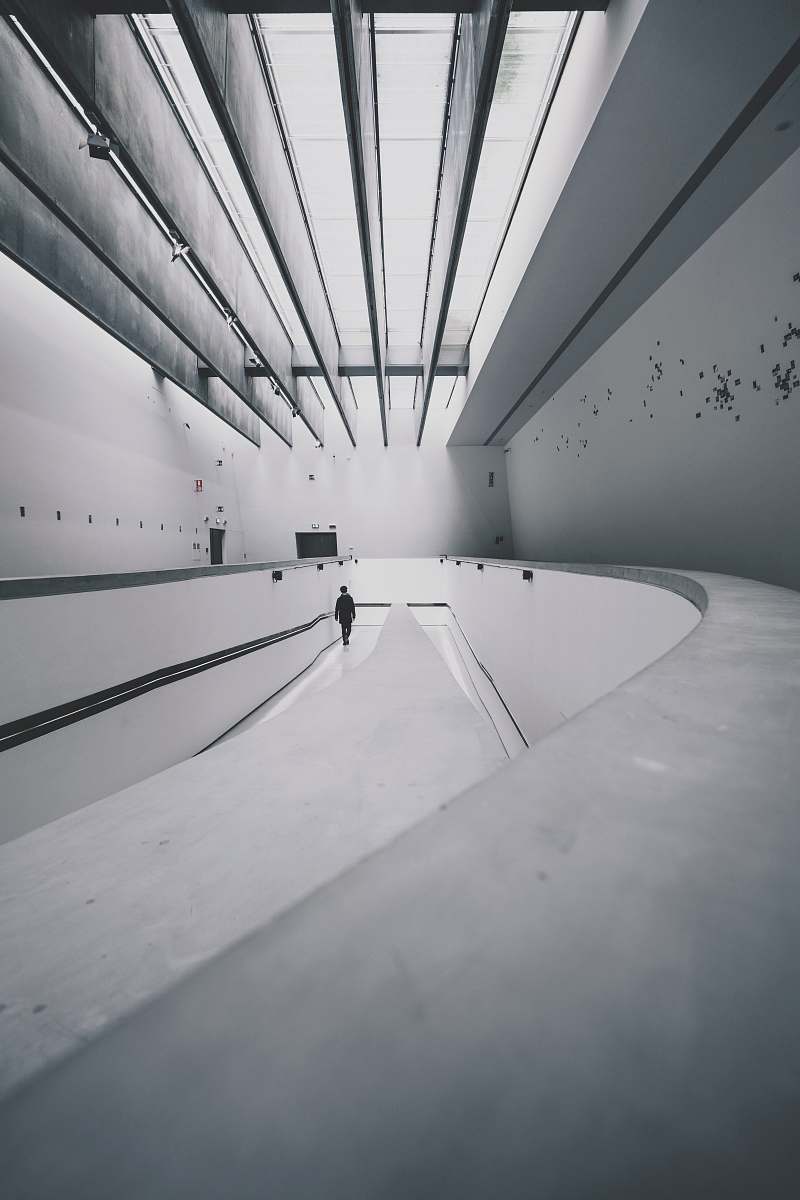 grey person walking beside wall lines