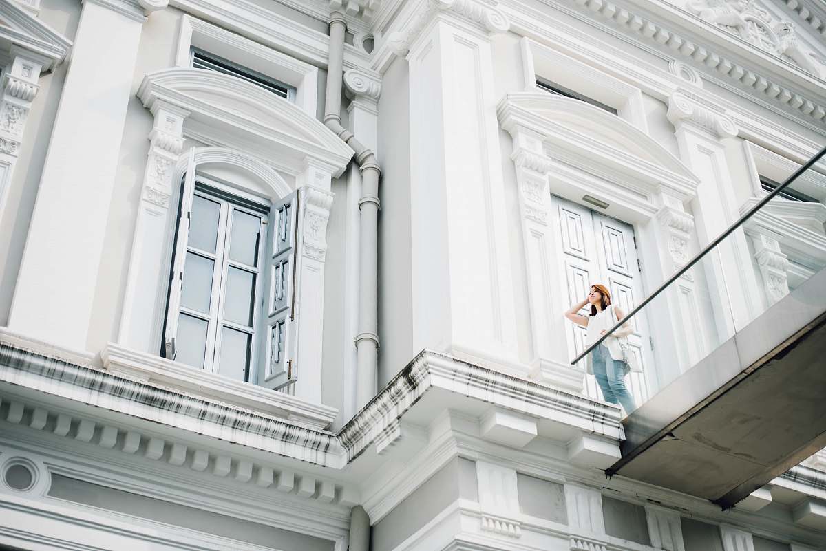 person woman standing on white concrete building terrace building