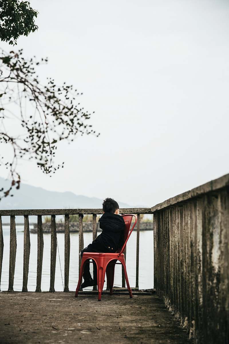 handrail boy sitting on armless chair beside baluster railing