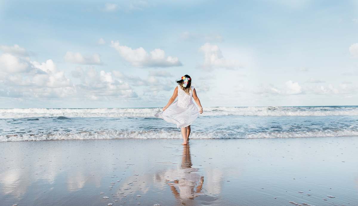 ocean woman in white dress walking on shore at daytime sea