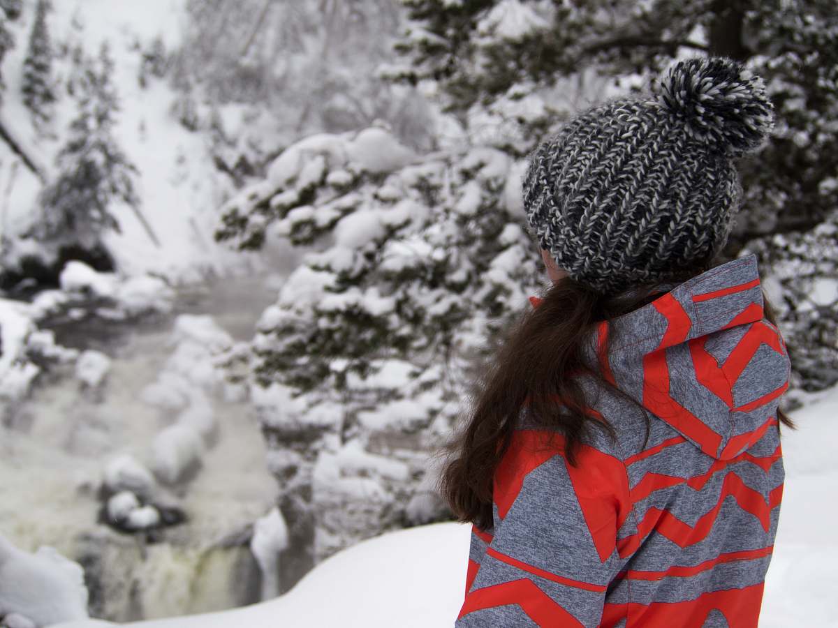 hat woman standing on snow field near trees winter
