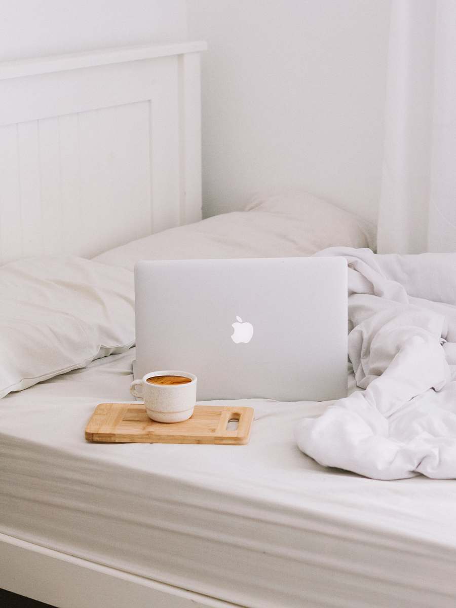 computer MacBook beside teacup with latte furniture