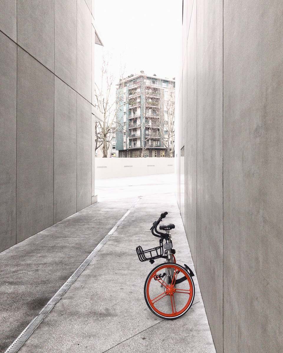 bike black and orange bicycle in between concrete walls italy