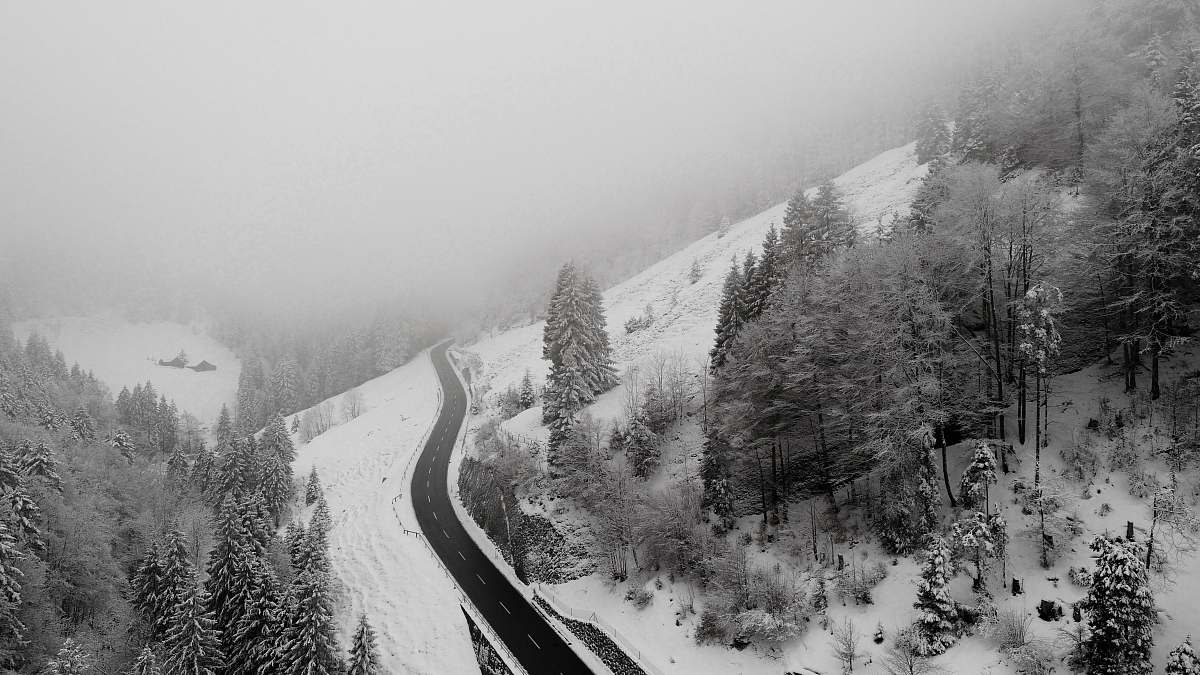 grey areal photography of roadway covered with snow switzerland