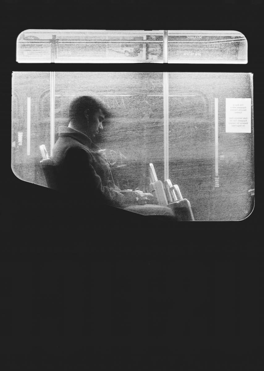 grey Black and white shot of man sitting on night bus through dirty window in Boston window