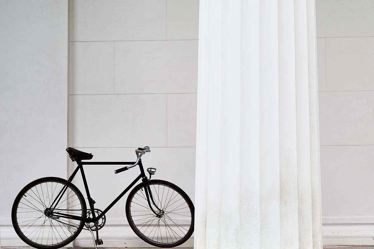 bicycle black bicycle standing on white concrete building bike