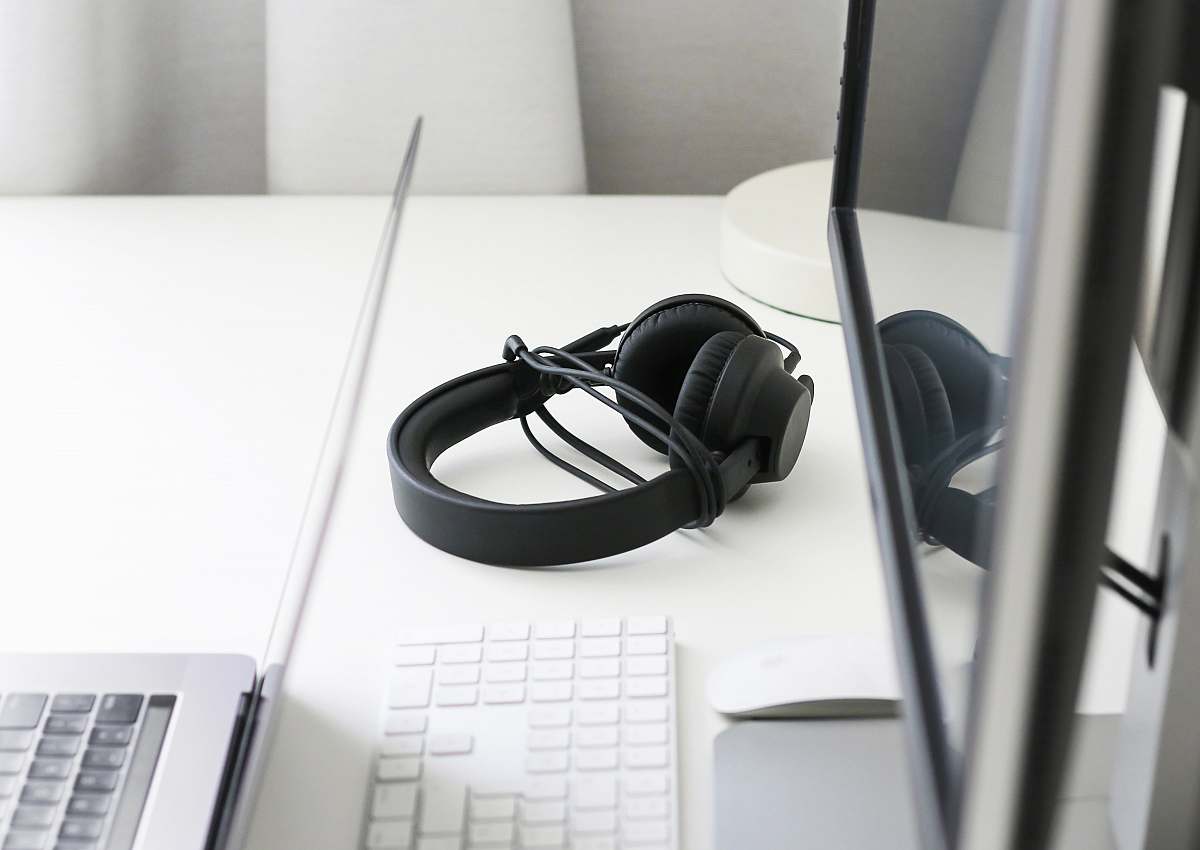 keyboard black corded headphones on white wooden table adapter