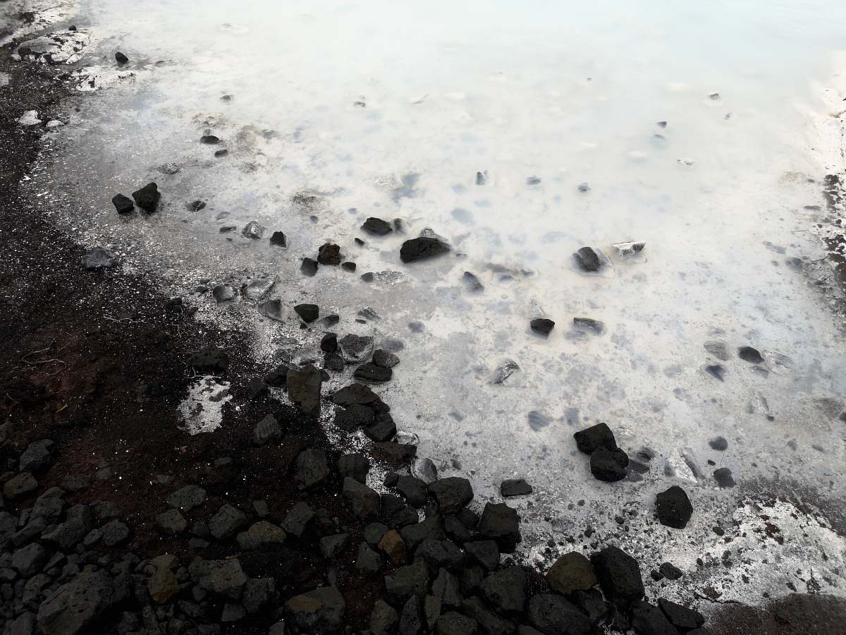 grey body of water near rocks rubble