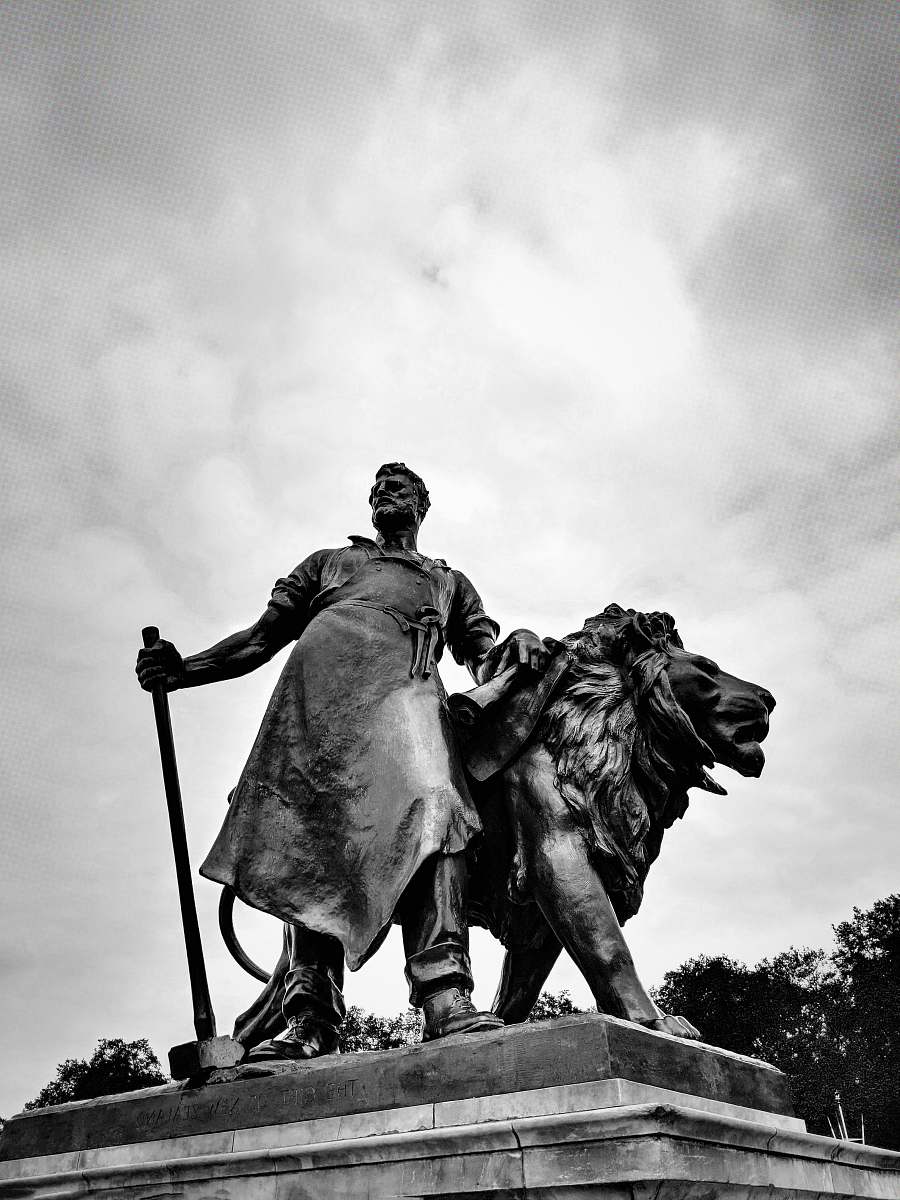 monument concrete man beside lion statue statue