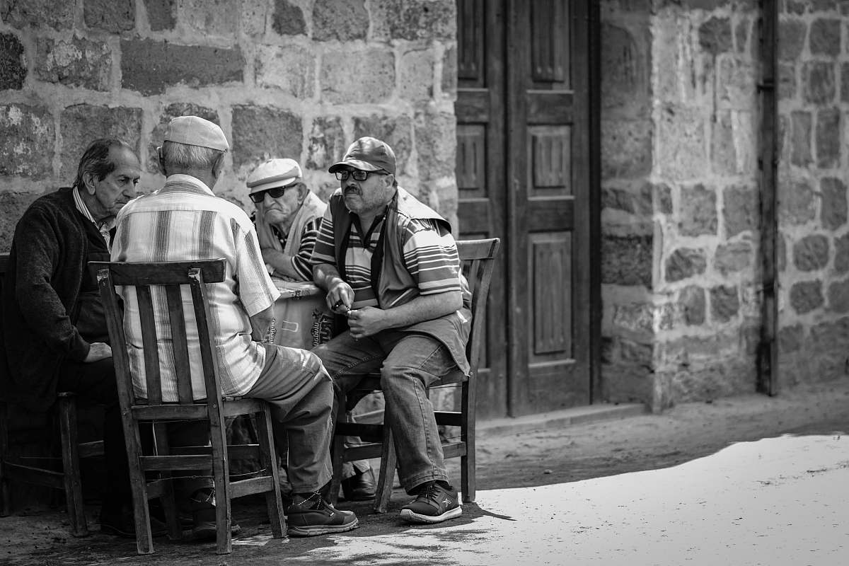 person four man sitting on brown wooden chairs chair